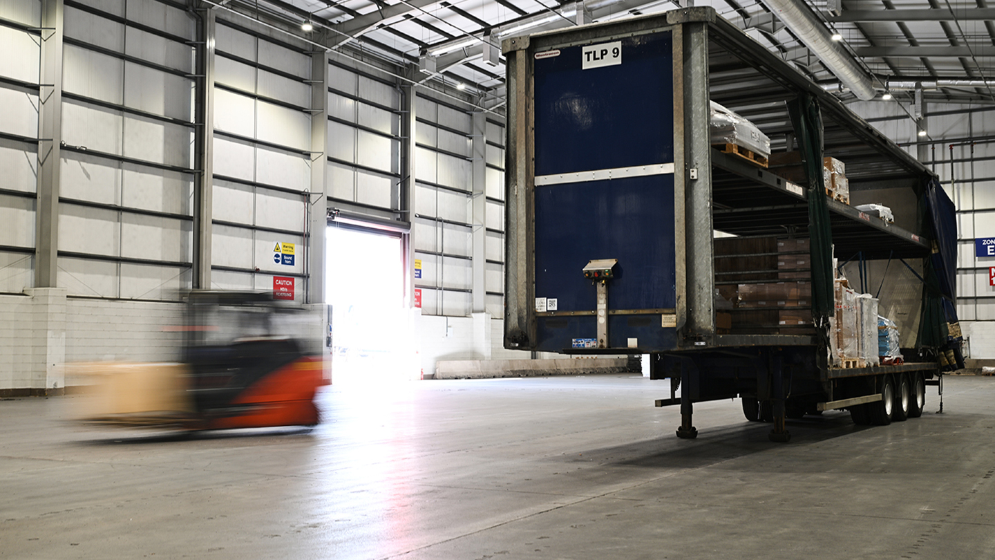 Image of a lorry and a forklift driving past